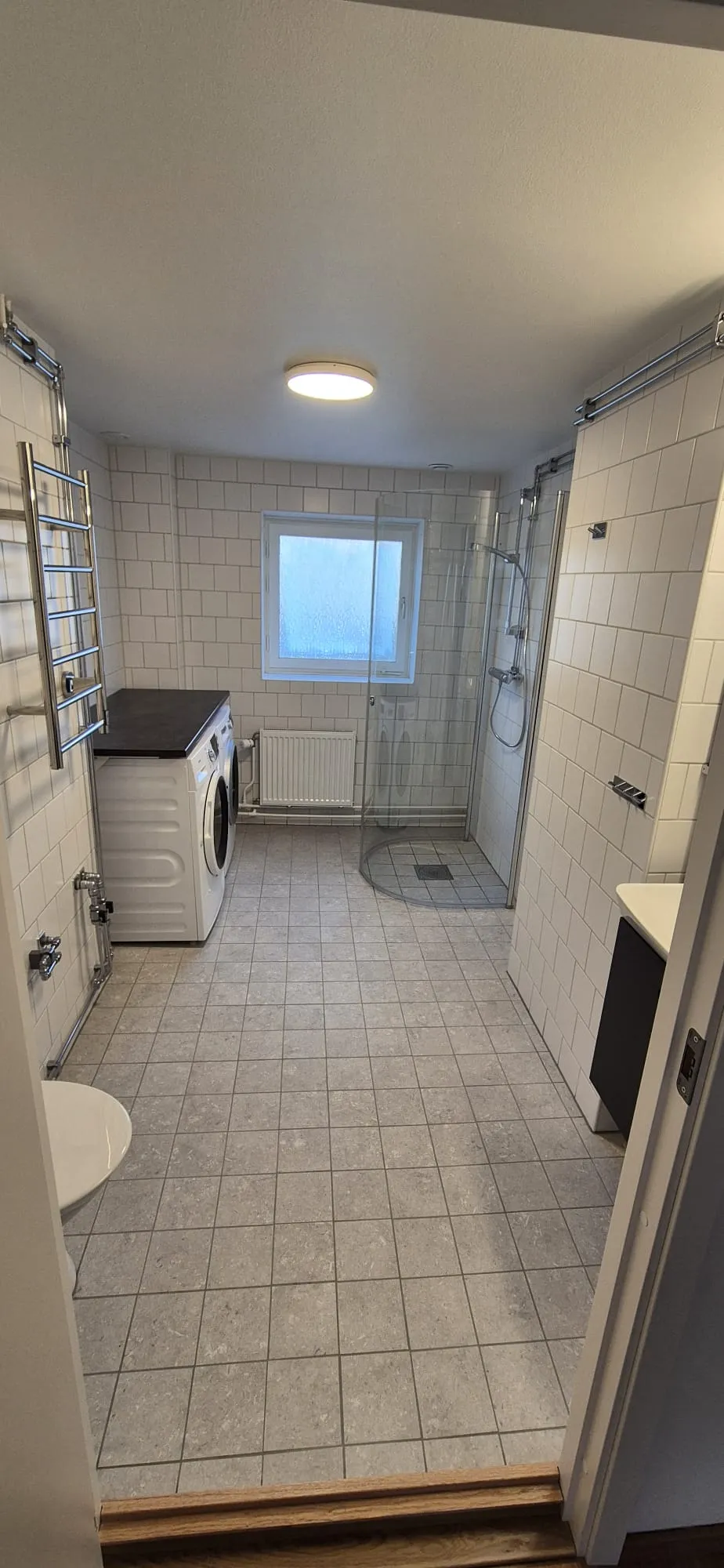 Badrum med tvättmaskin och fönster
